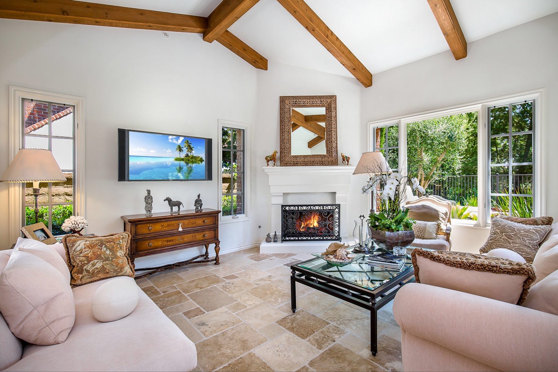 Great room with vaulted beamed ceiling and carved stone fireplace